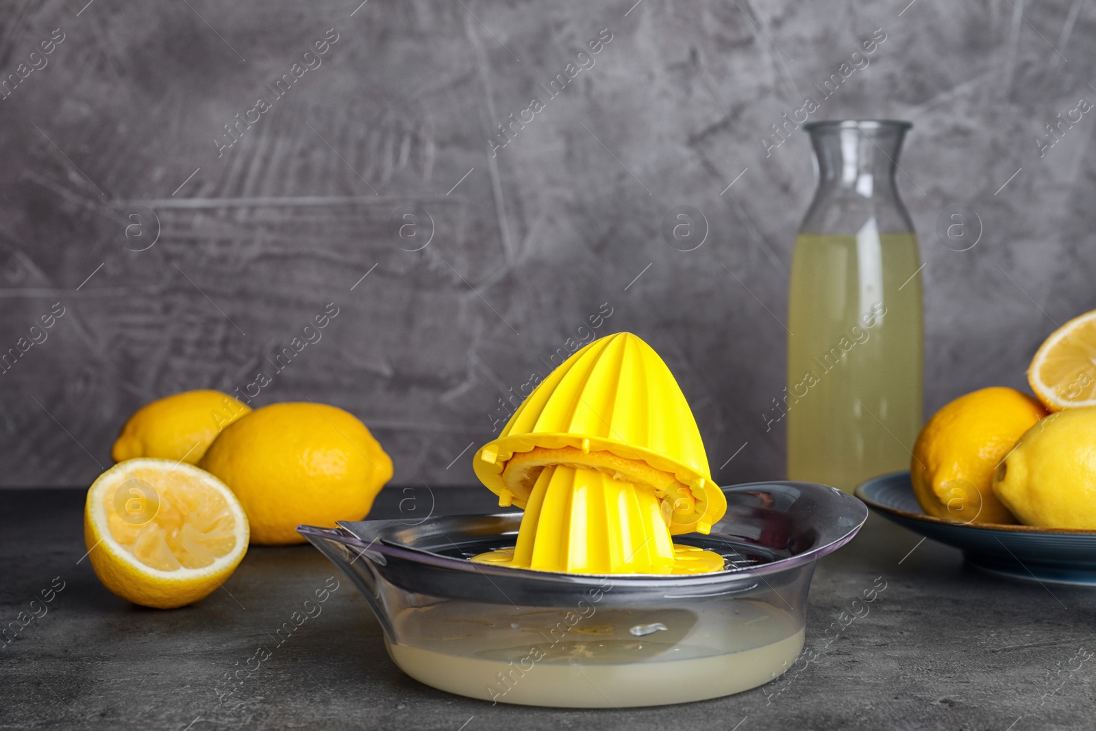 Photo of Composition with squeezer and lemons on table