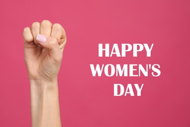 Image of Woman showing fist as girl power symbol on pink background, closeup. Happy Women's Day