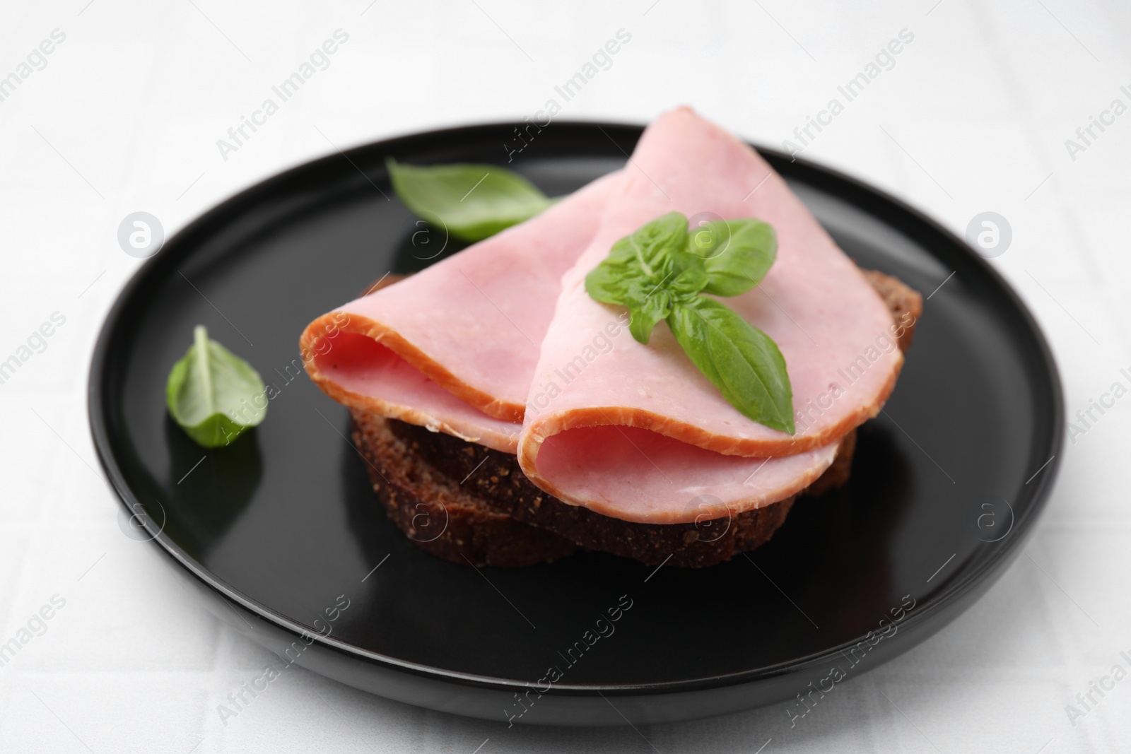 Photo of Delicious sandwich with ham on white table, closeup