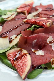 Photo of Delicious bresaola salad on plate, closeup view