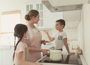 Photo of Happy family cooking together in kitchen at home