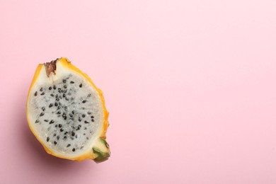 Photo of Delicious cut dragon fruit (pitahaya) on pink background, top view. Space for text