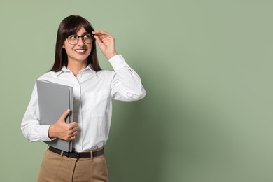 Photo of Happy secretary with folder on light olive background. Space for text