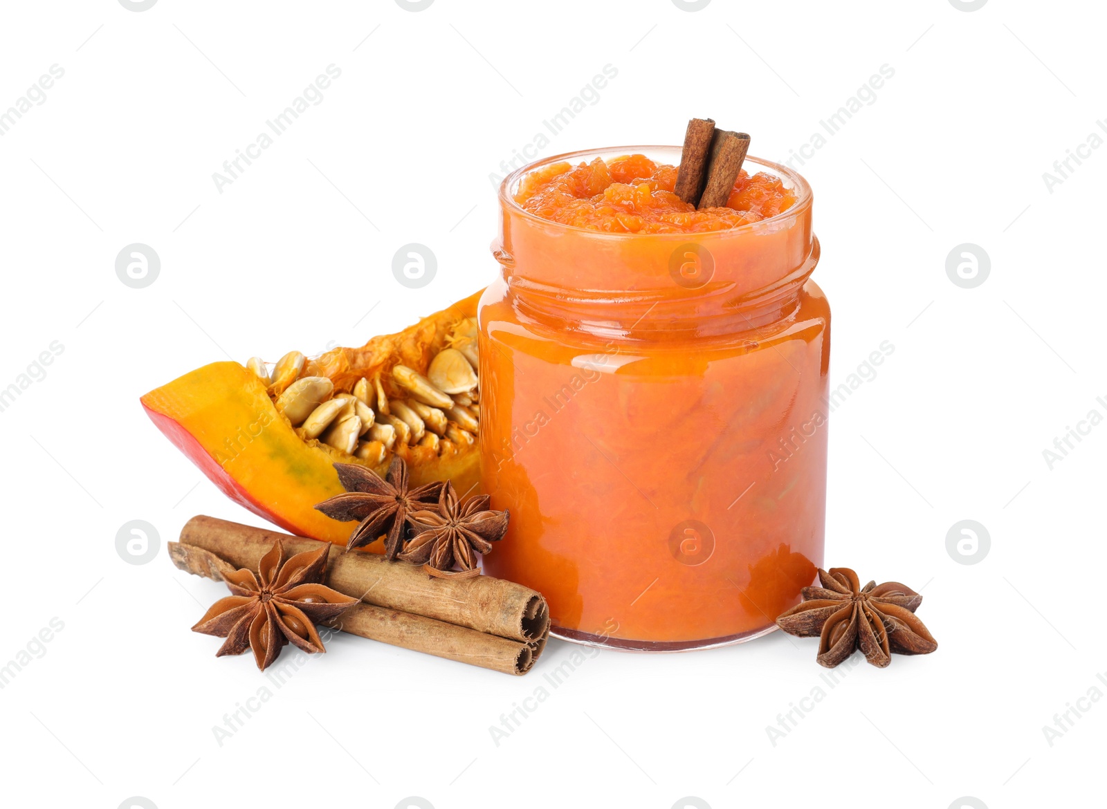 Photo of Jar of pumpkin jam, star anise, fresh pumpkin and cinnamon on white background