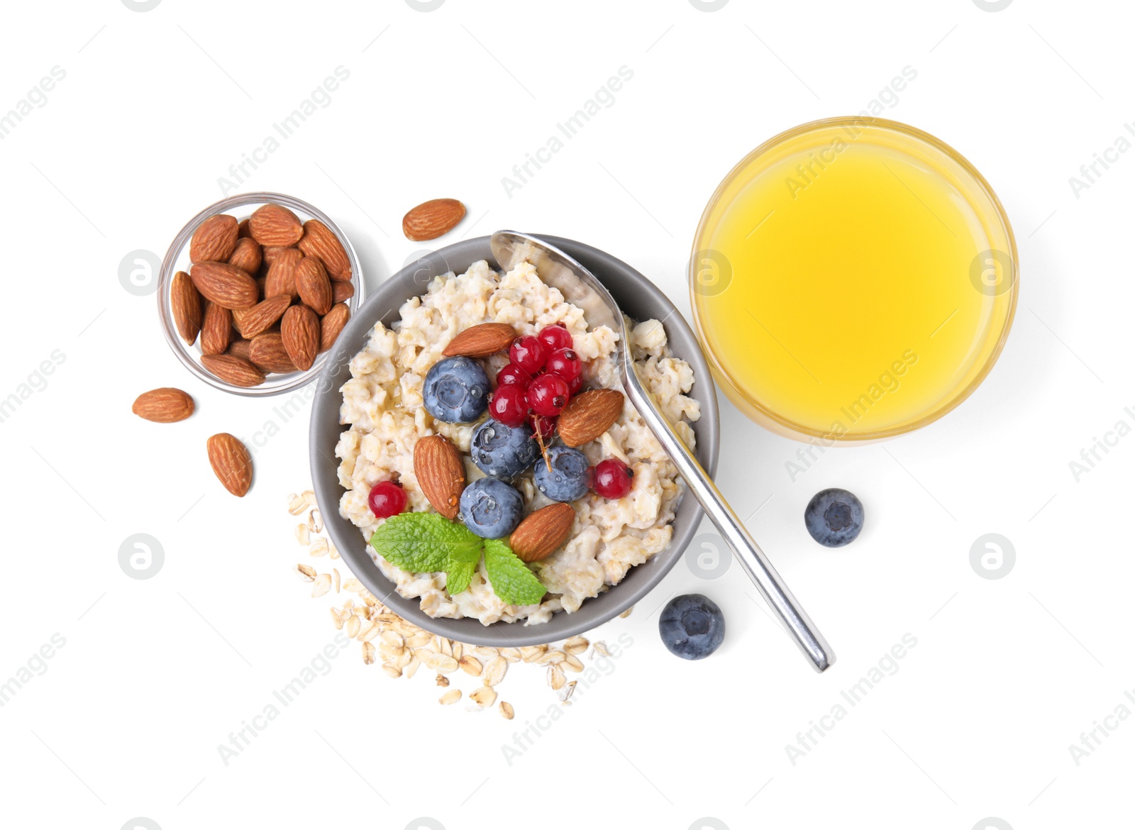 Photo of Oatmeal served with berries, almonds and honey on white background, top view