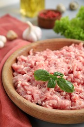 Photo of Raw chicken minced meat with basil on table, closeup