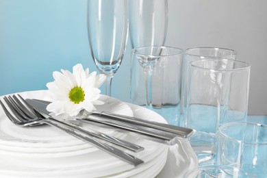 Set of clean dishes, glasses and cutlery on table, closeup