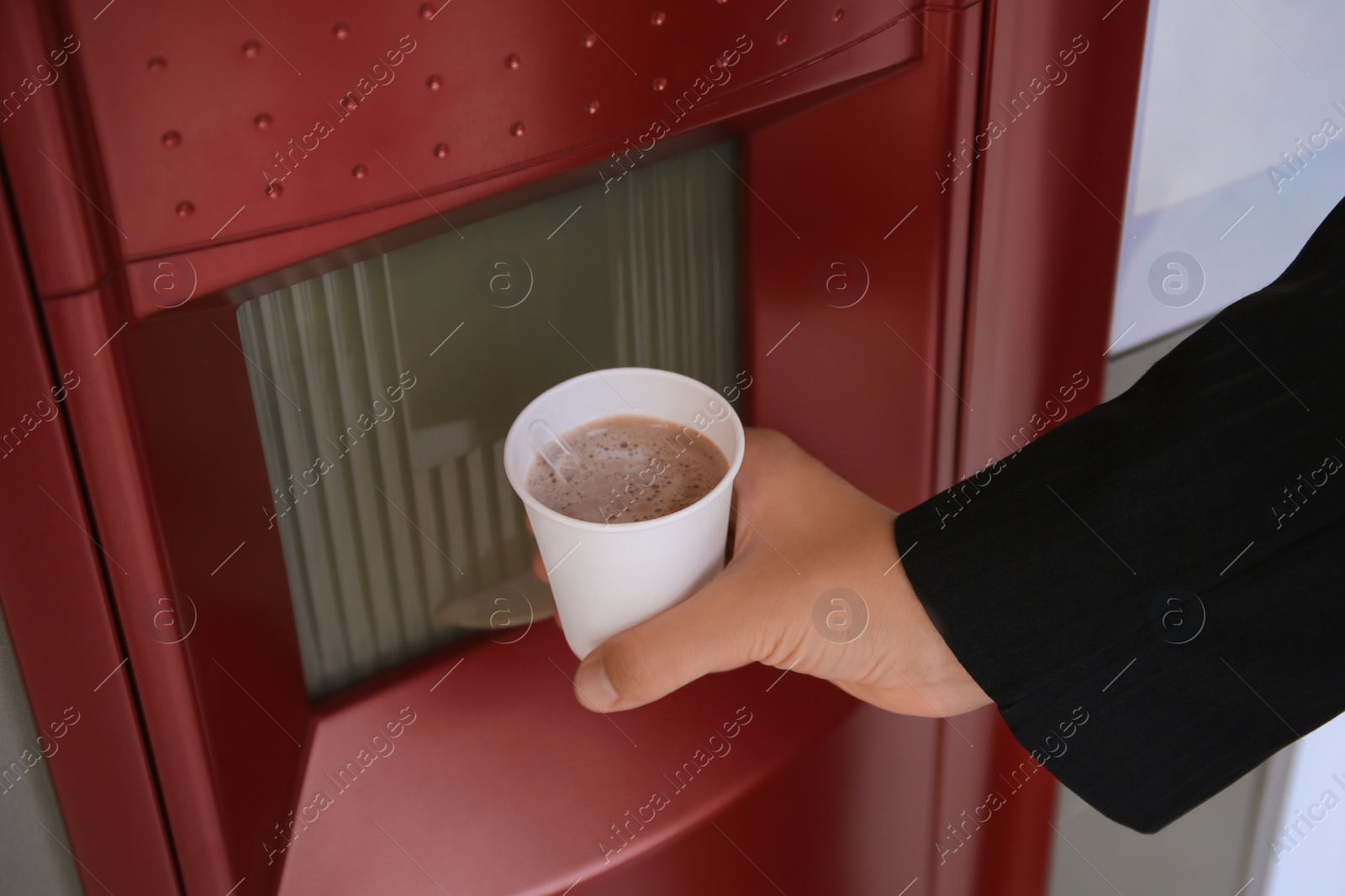 Photo of Woman taking paper cup with coffee from vending machine, closeup