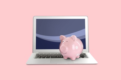 Image of Piggy bank and laptop on pink background. Online banking