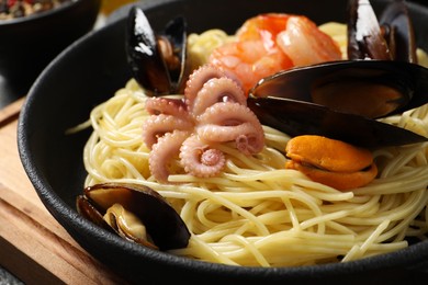 Delicious pasta with sea food in frying pan, closeup