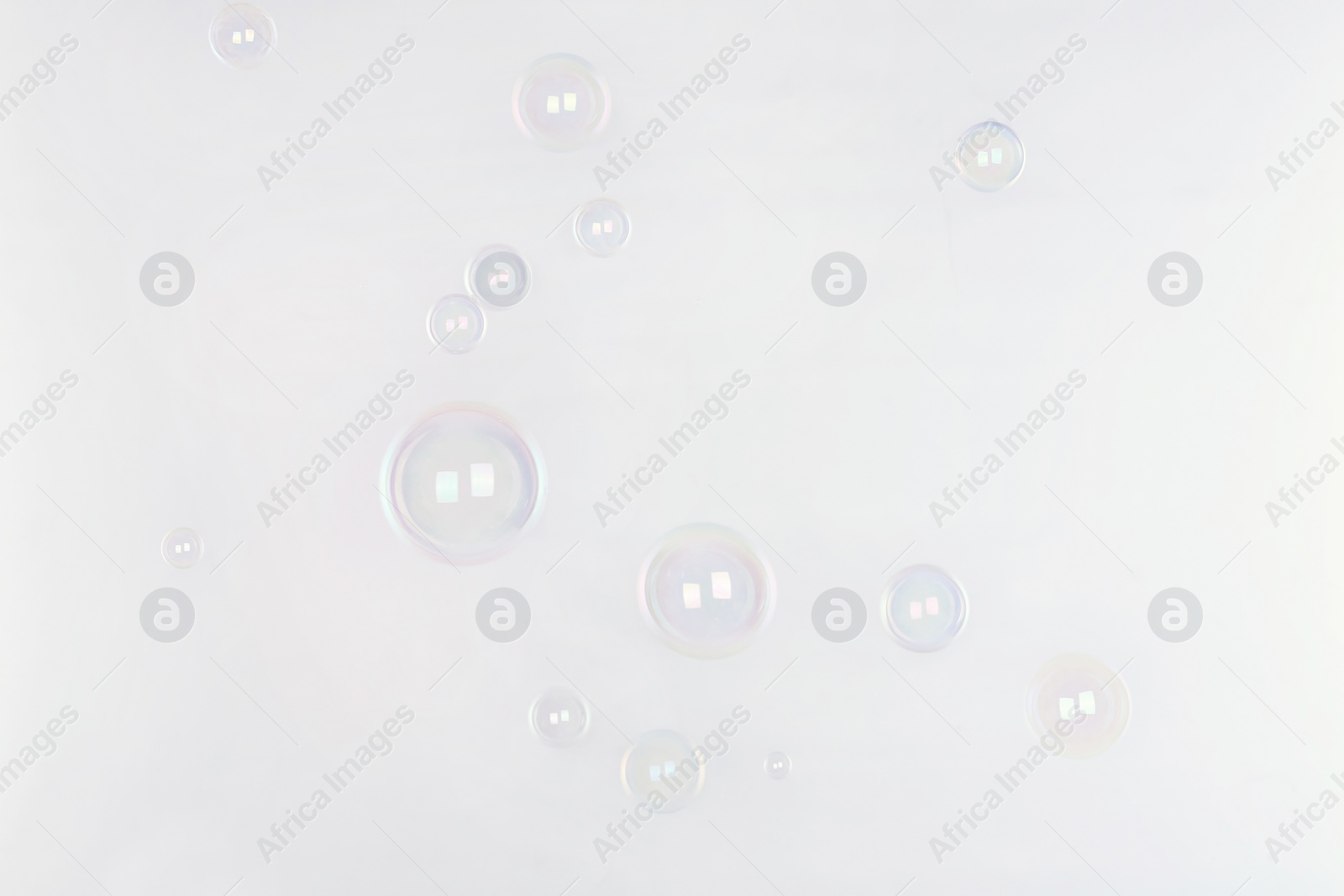 Photo of Beautiful translucent soap bubbles on light background