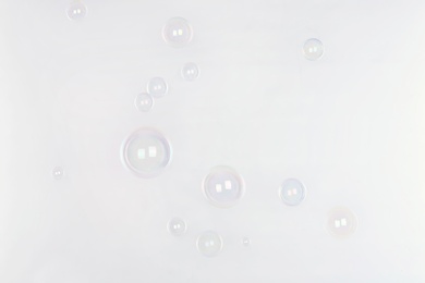 Photo of Beautiful translucent soap bubbles on light background