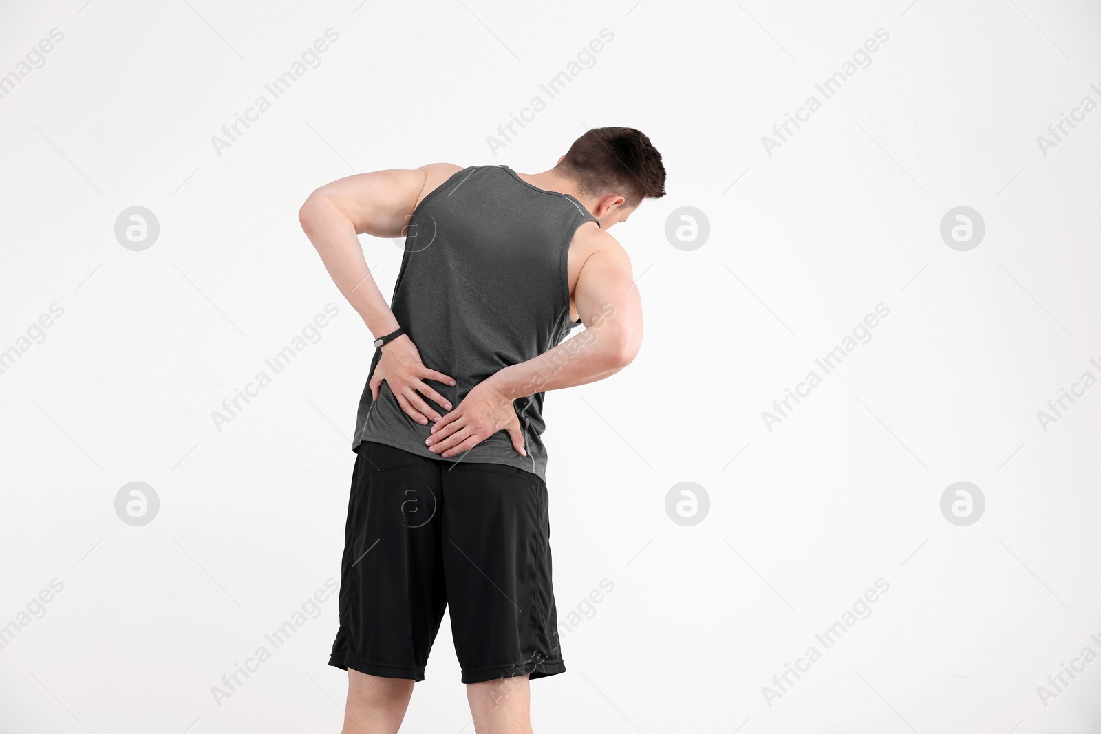 Photo of Man in sportswear suffering from back pain on white background