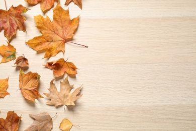 Photo of Flat lay composition with autumn leaves on wooden background. Space for text