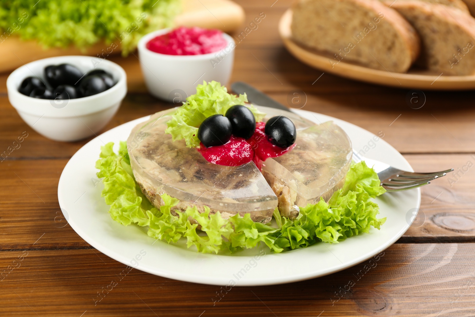 Photo of Delicious aspic with meat served on wooden table