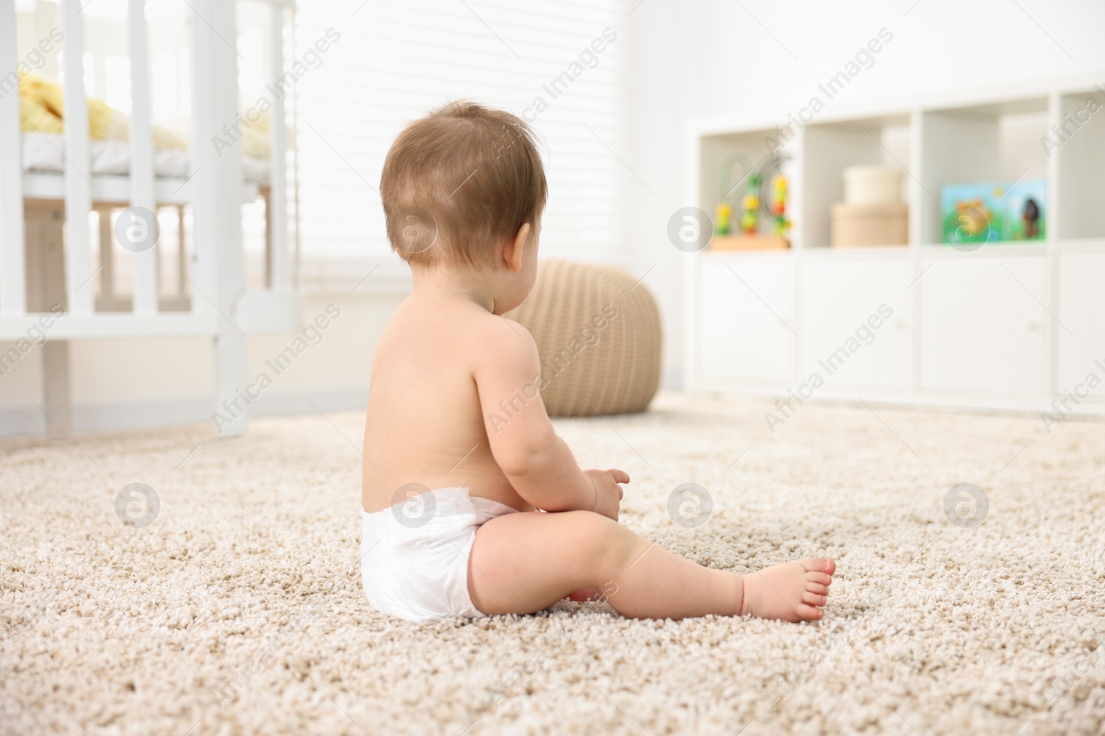 Photo of Baby boy sitting on carpet at home