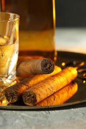 Tray with whiskey and cigars on grey table, closeup
