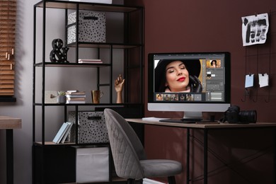 Photo of Retoucher's workplace. Computer with photo editor application, camera and graphic tablet on table in office