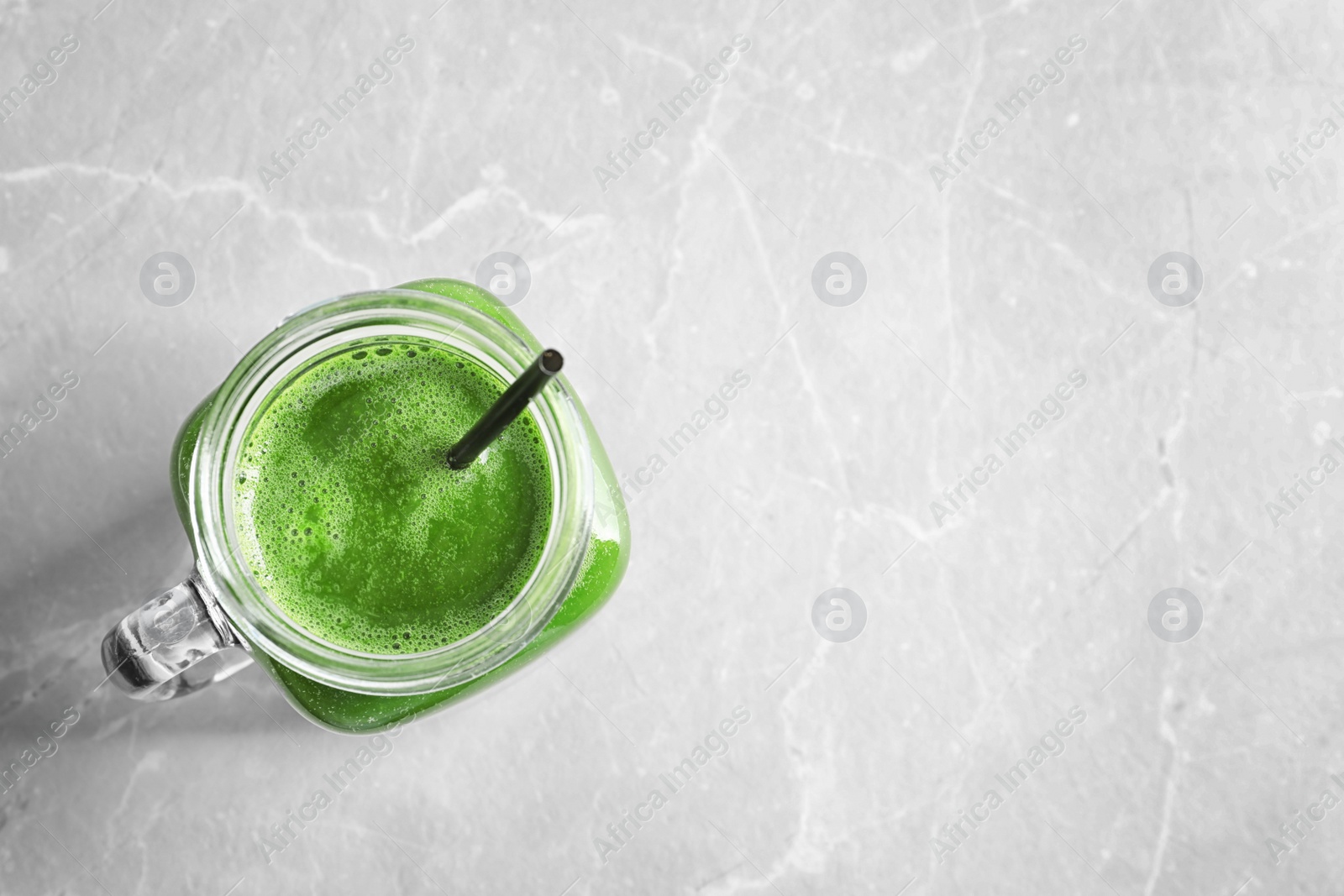 Photo of Mason jar with delicious detox juice on light background, top view