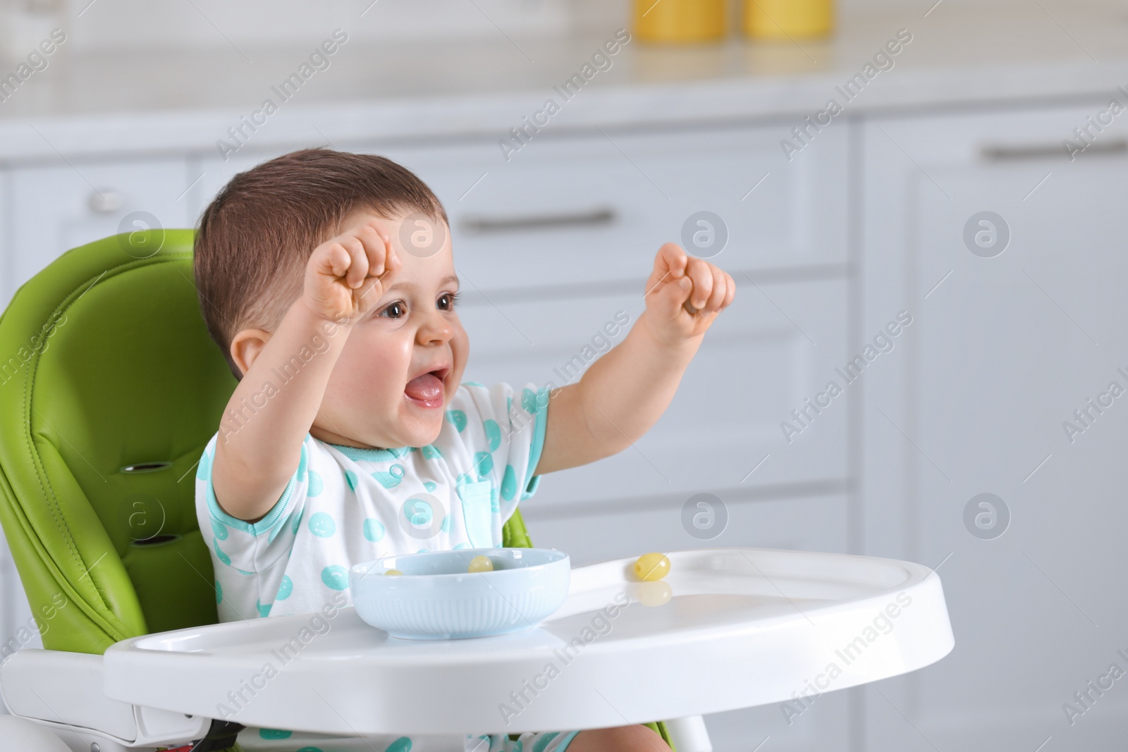 Photo of Cute little baby eating healthy food in high chair at home, space for text