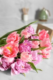 Beautiful bouquet of colorful tulip flowers on white table indoors
