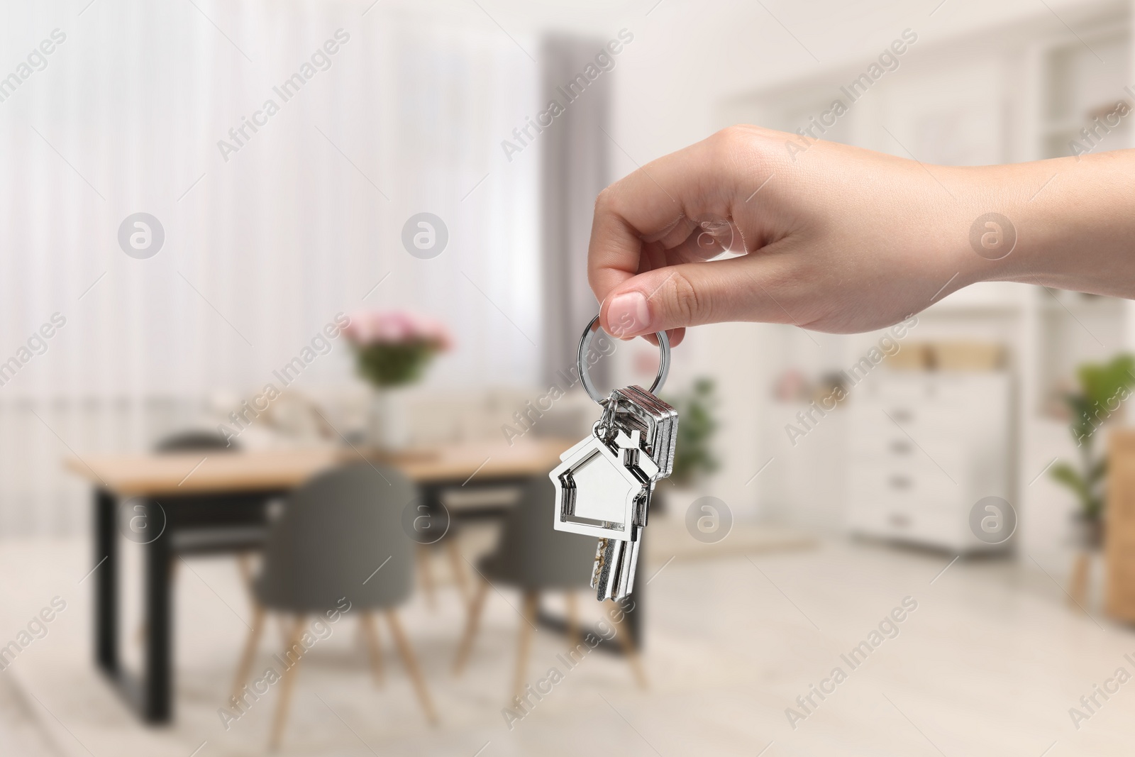 Image of Woman holding house keys in room, closeup