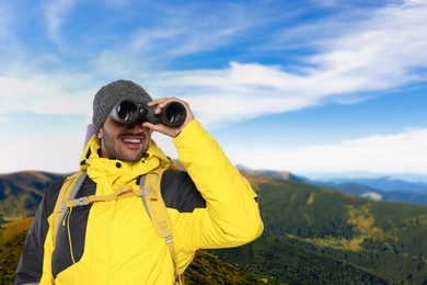 Image of Tourist with backpack and binoculars in mountains