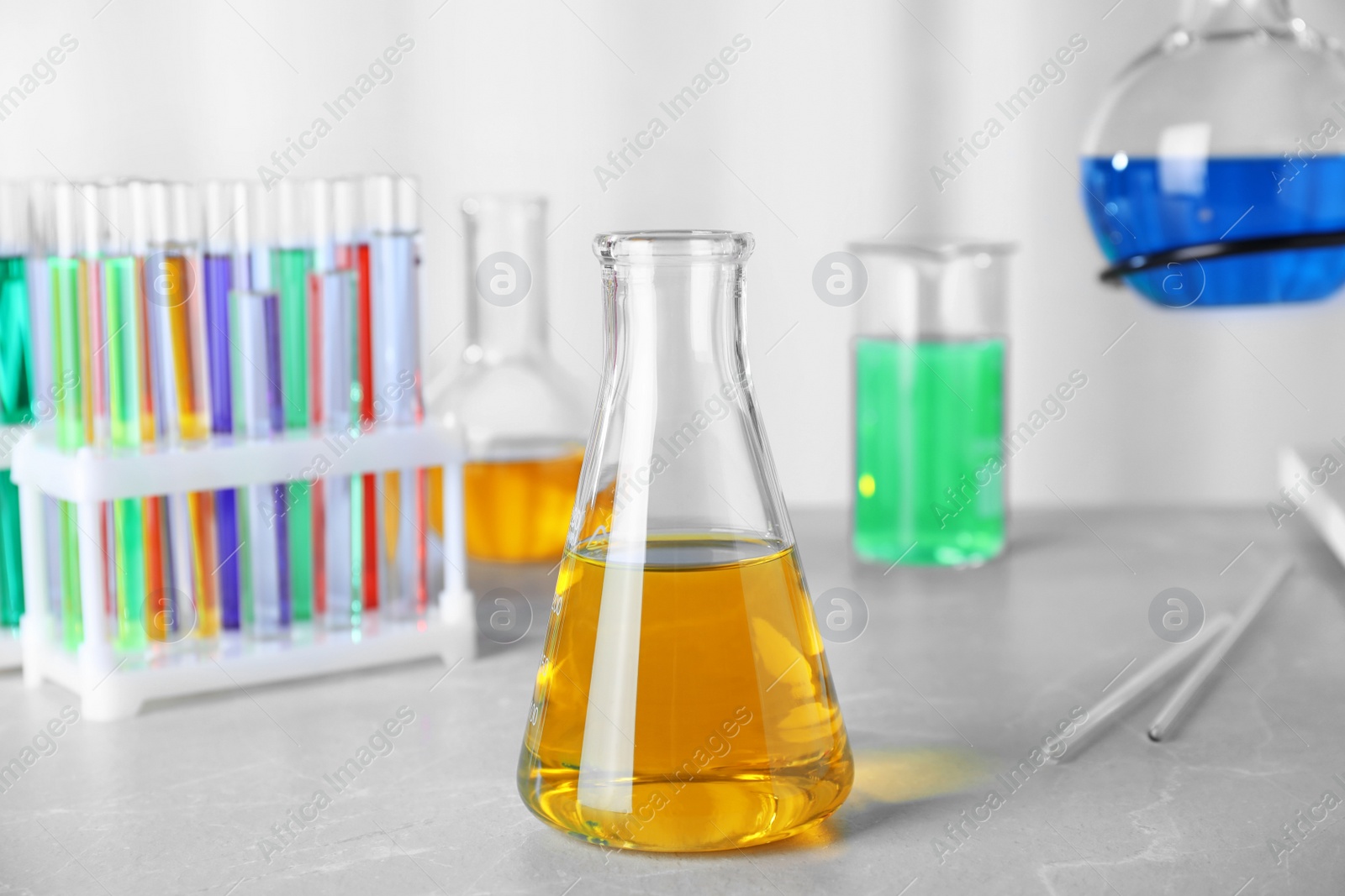 Photo of Laboratory glassware with samples on table indoors. Solution chemistry