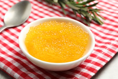 Photo of Fresh pike caviar in bowl and rosemary on table, closeup