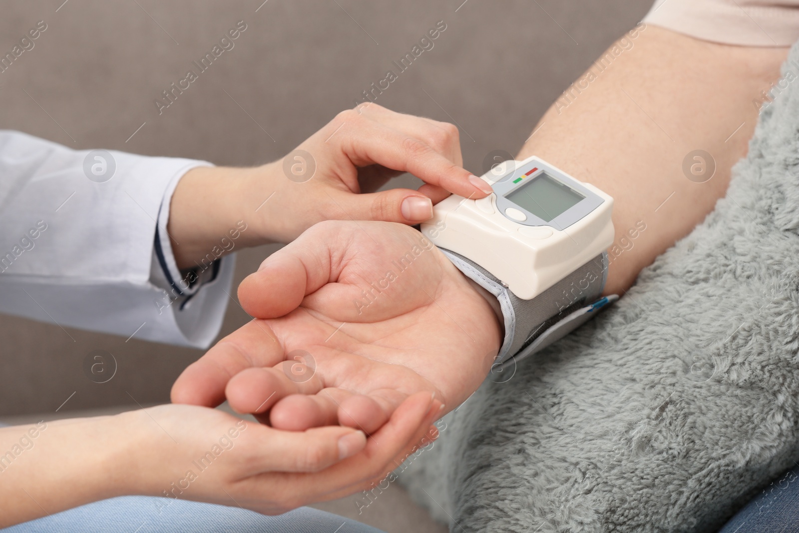 Photo of Nurse measuring blood pressure of elderly man against grey background, closeup. Assisting senior generation