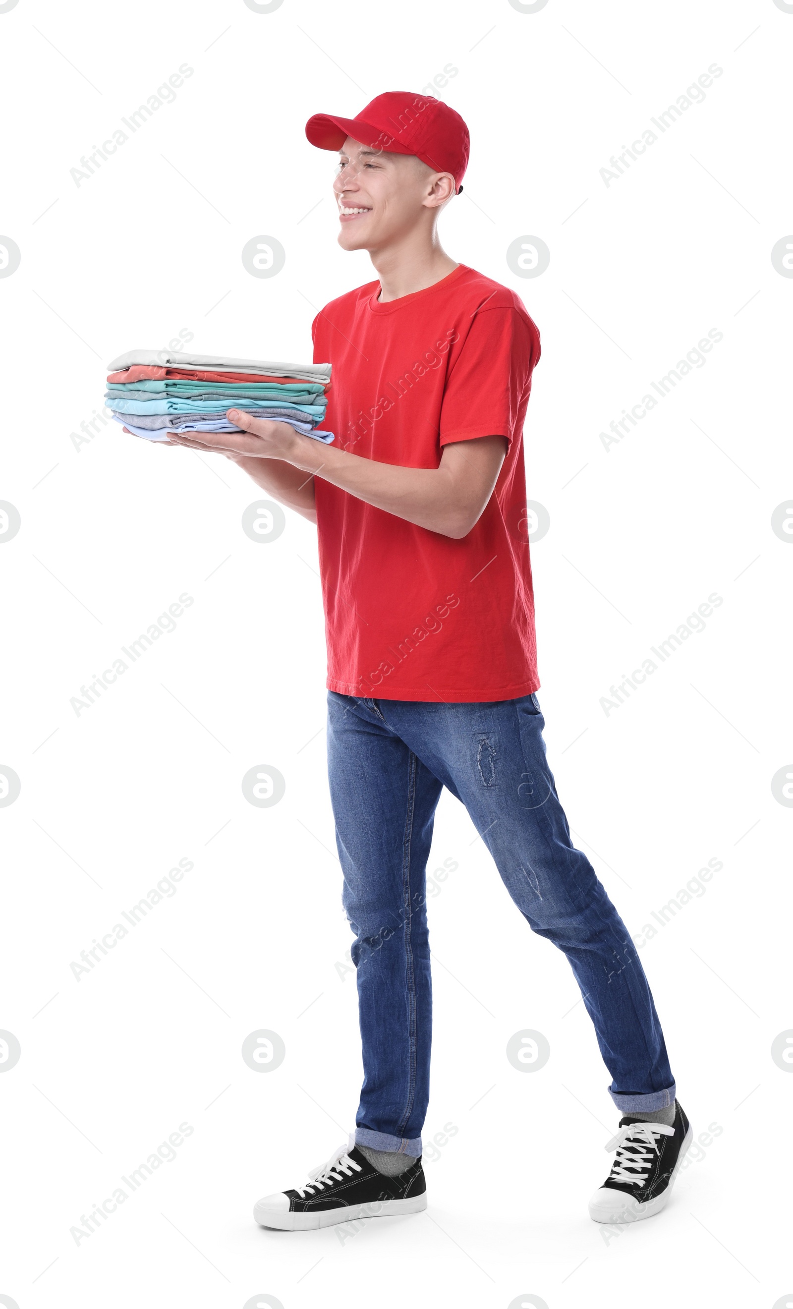 Photo of Dry-cleaning delivery. Happy courier holding folded clothes on white background