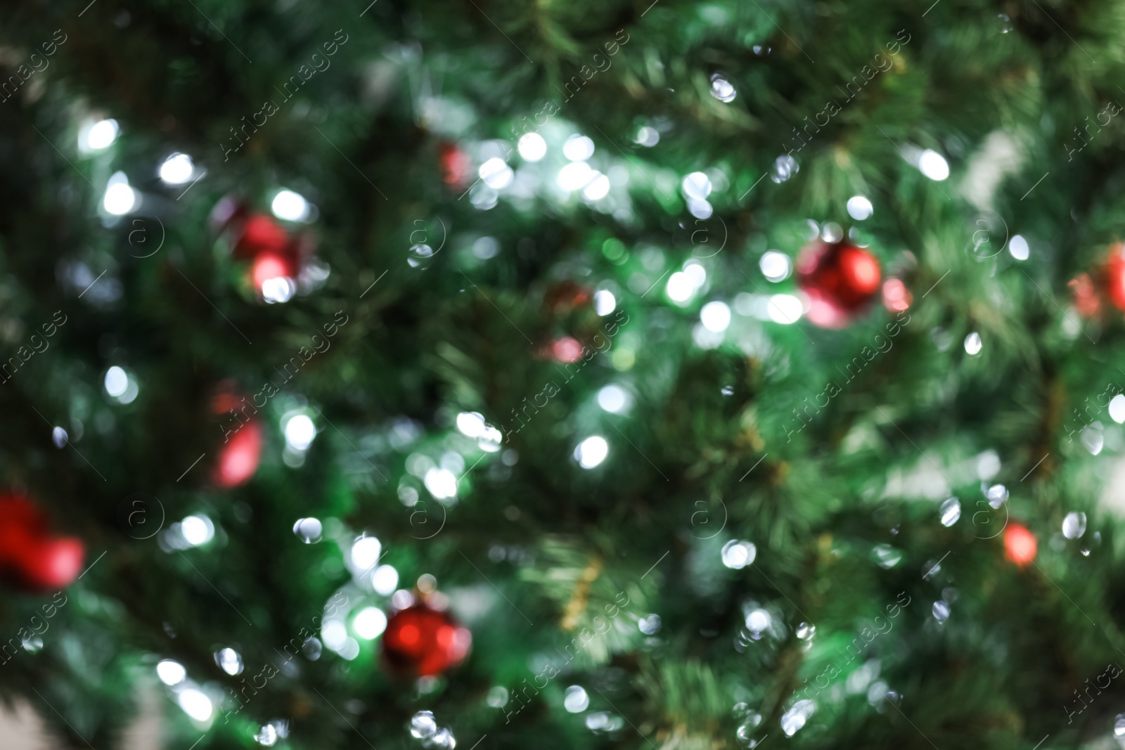 Photo of Blurred view of Christmas tree with bright string lights and ornaments, closeup. Bokeh effect