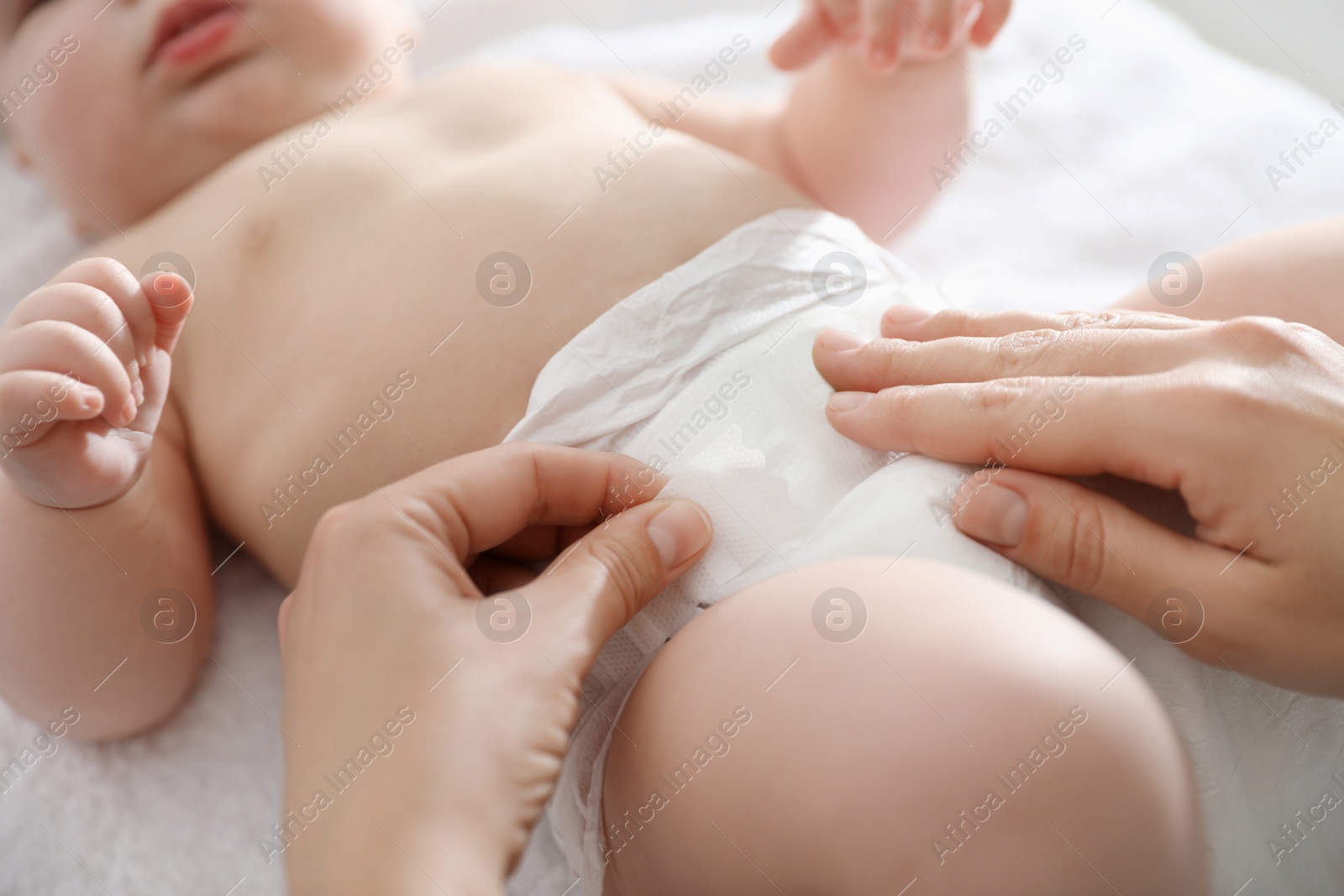 Photo of Mother changing her baby's diaper on table, closeup