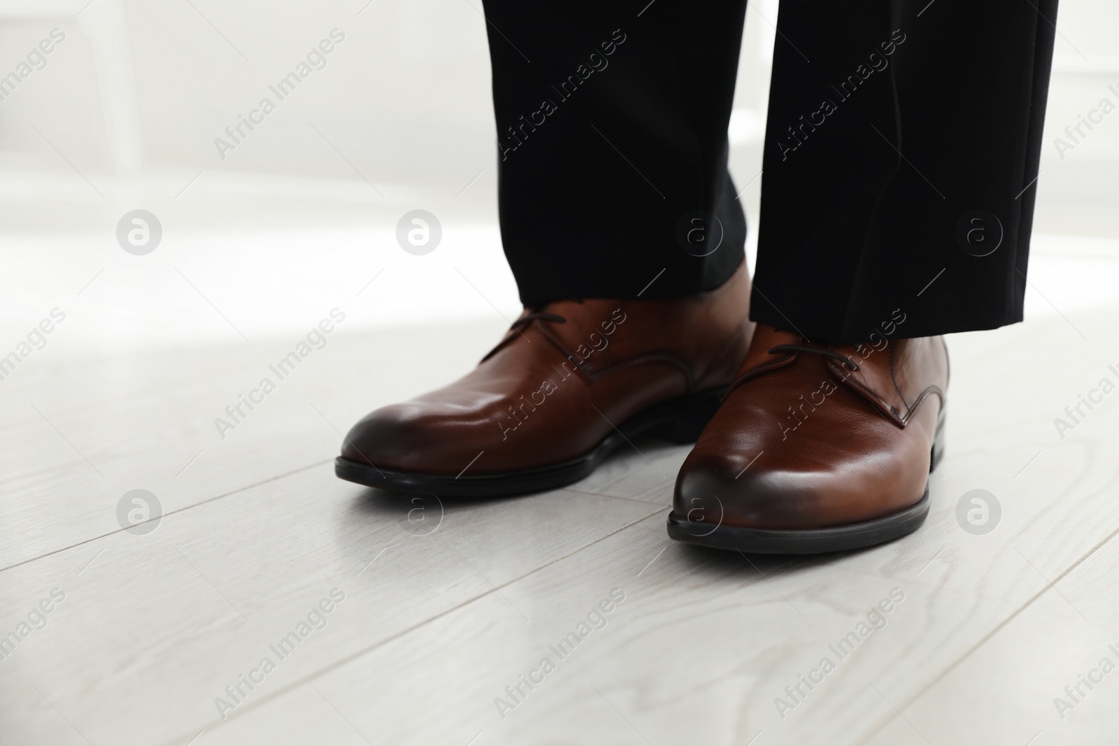 Photo of Groom wearing elegant wedding shoes indoors, closeup