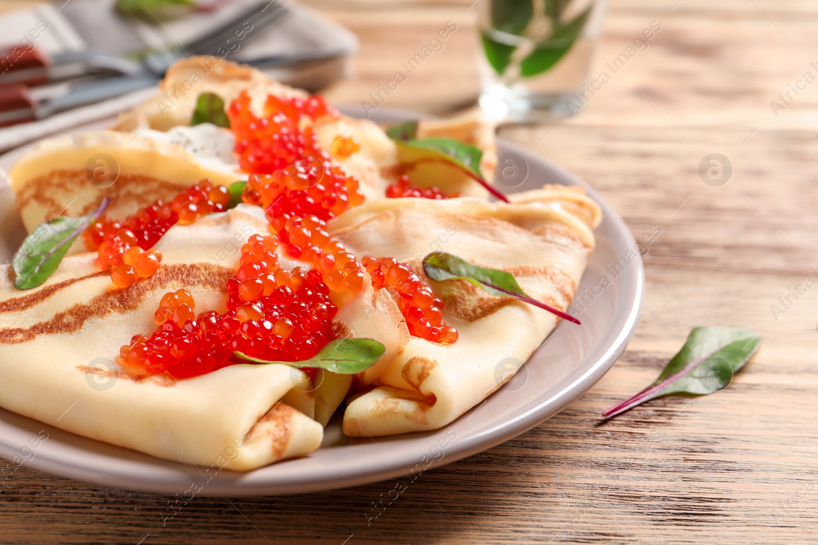 Photo of Thin pancakes with red caviar on plate