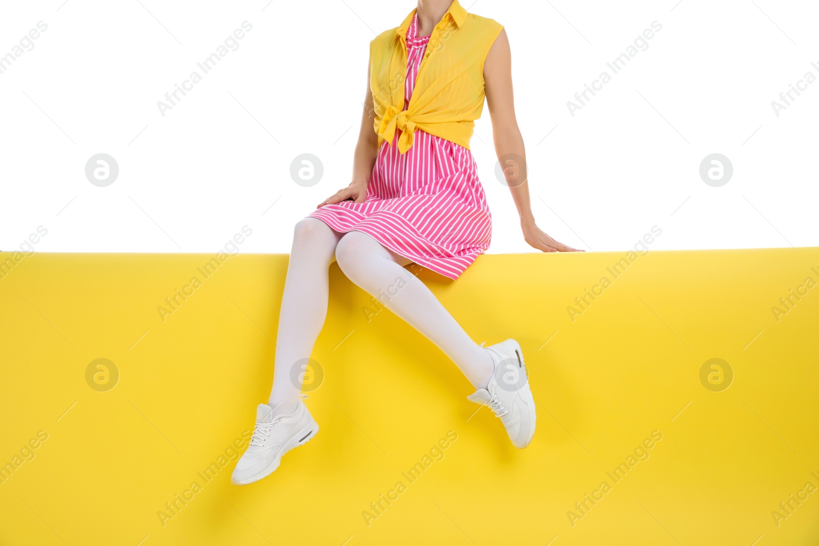 Photo of Woman wearing white tights sitting on color background, closeup