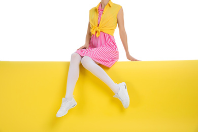 Photo of Woman wearing white tights sitting on color background, closeup
