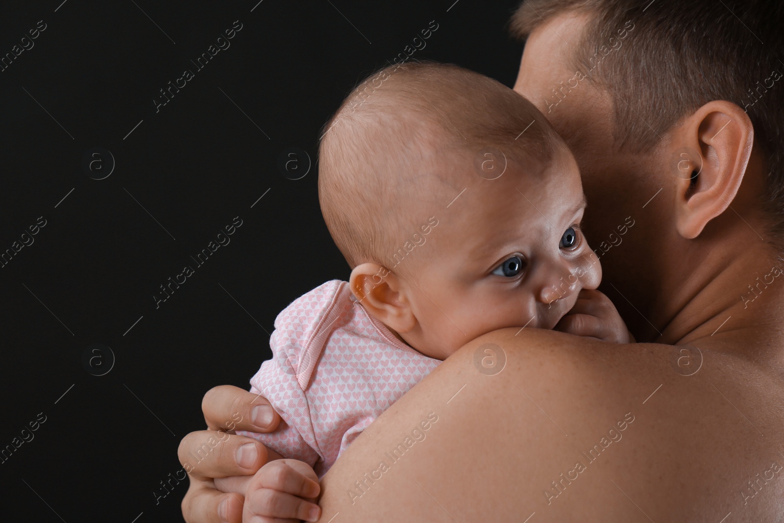 Photo of Father with his little baby on black background