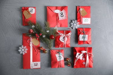 Set of different gifts and Christmas decor on grey stone table, flat lay. Advent calendar