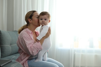 Photo of Young woman with her cute baby at home. Space for text