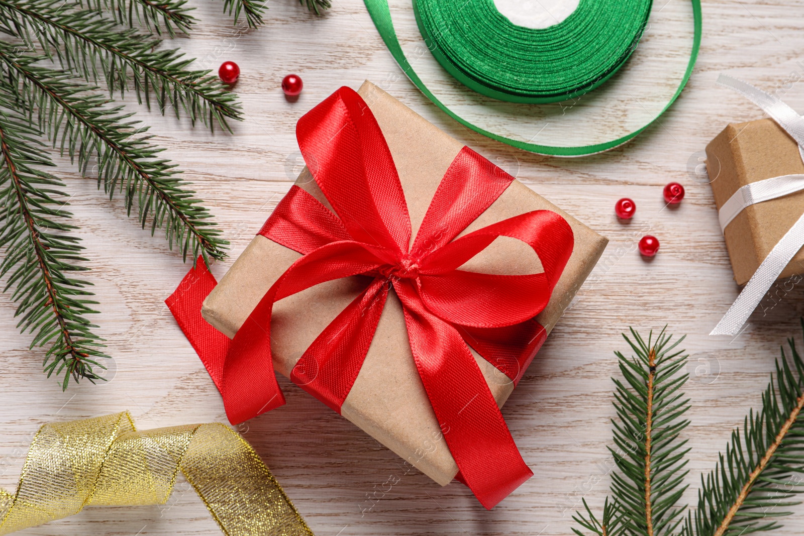 Photo of Beautiful gift box and decorations on white wooden table, flat lay. Christmas present