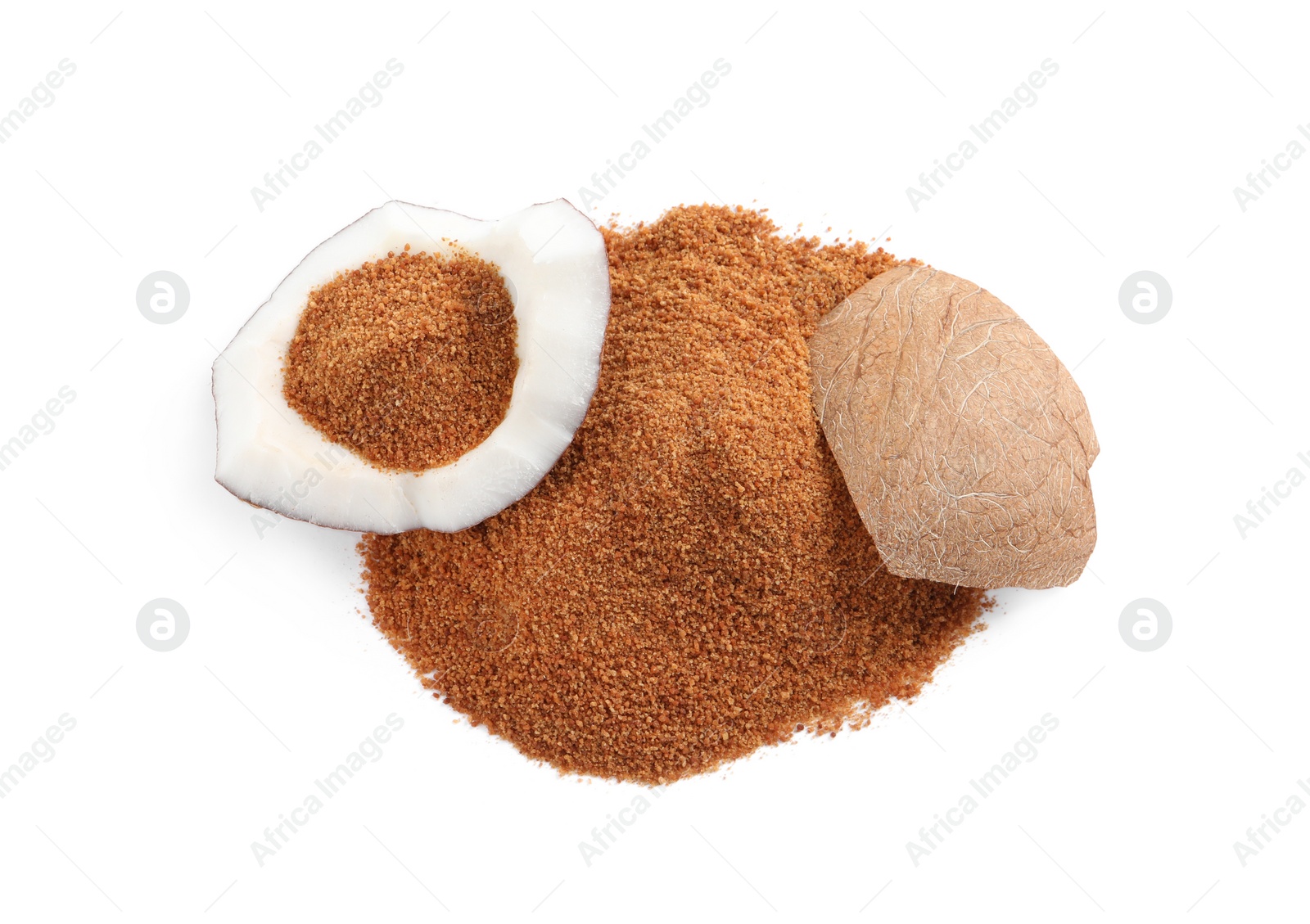 Photo of Ripe coconut and pile of brown sugar on white background, top view
