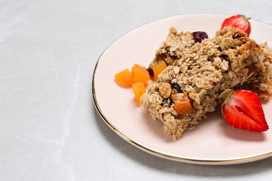Photo of Tasty granola bars and ingredients on light grey marble table, space for text