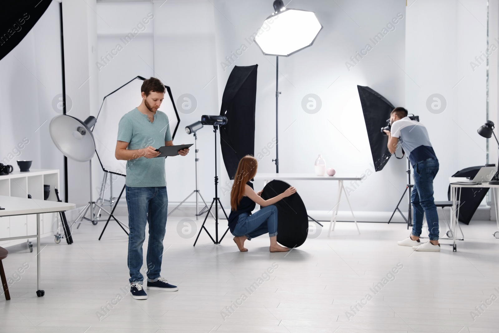 Photo of Photo studio with professional equipment and team of workers