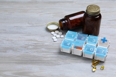 Weekly pill box with medicaments on wooden table. Space for text