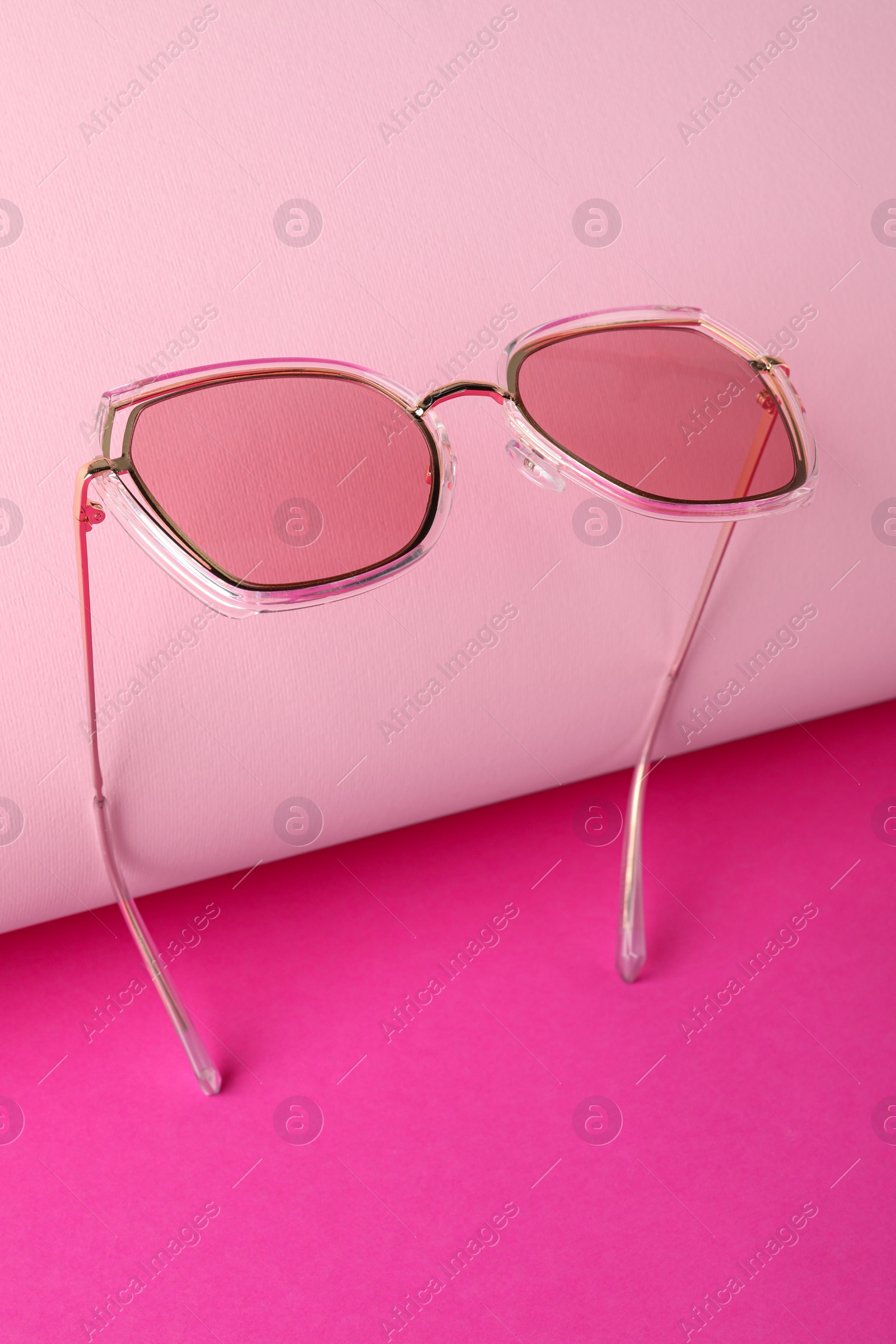 Photo of Stylish sunglasses on pink background. Summer accessory