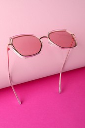 Stylish sunglasses on pink background. Summer accessory