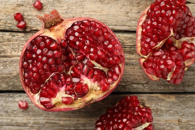 Photo of Cut fresh pomegranate on wooden table, top view