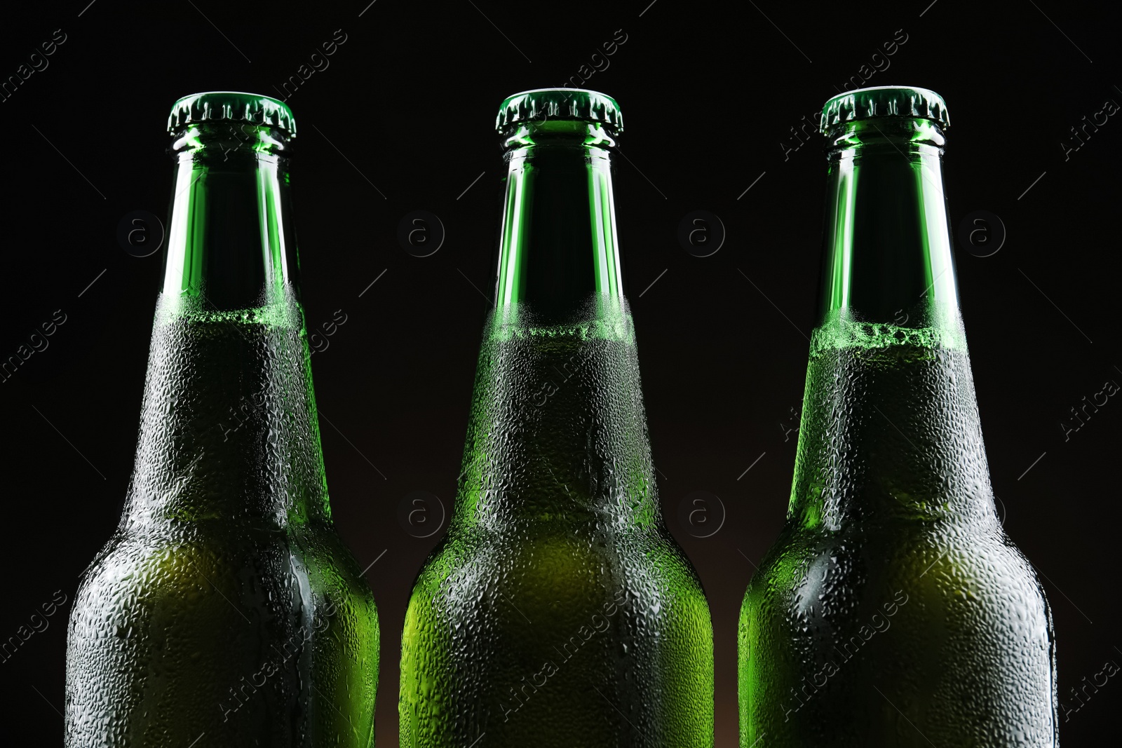 Photo of Many bottles of beer on black background, closeup