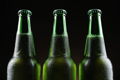 Photo of Many bottles of beer on black background, closeup